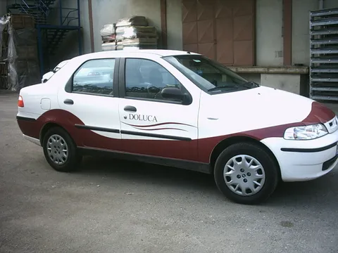 A2 Reklam tarafından uygulanan Doluca kurumsal aracı (Fiat Palio) kısmi araç giydirme - bordo/beyaz folyo kaplama, yan görünüm.