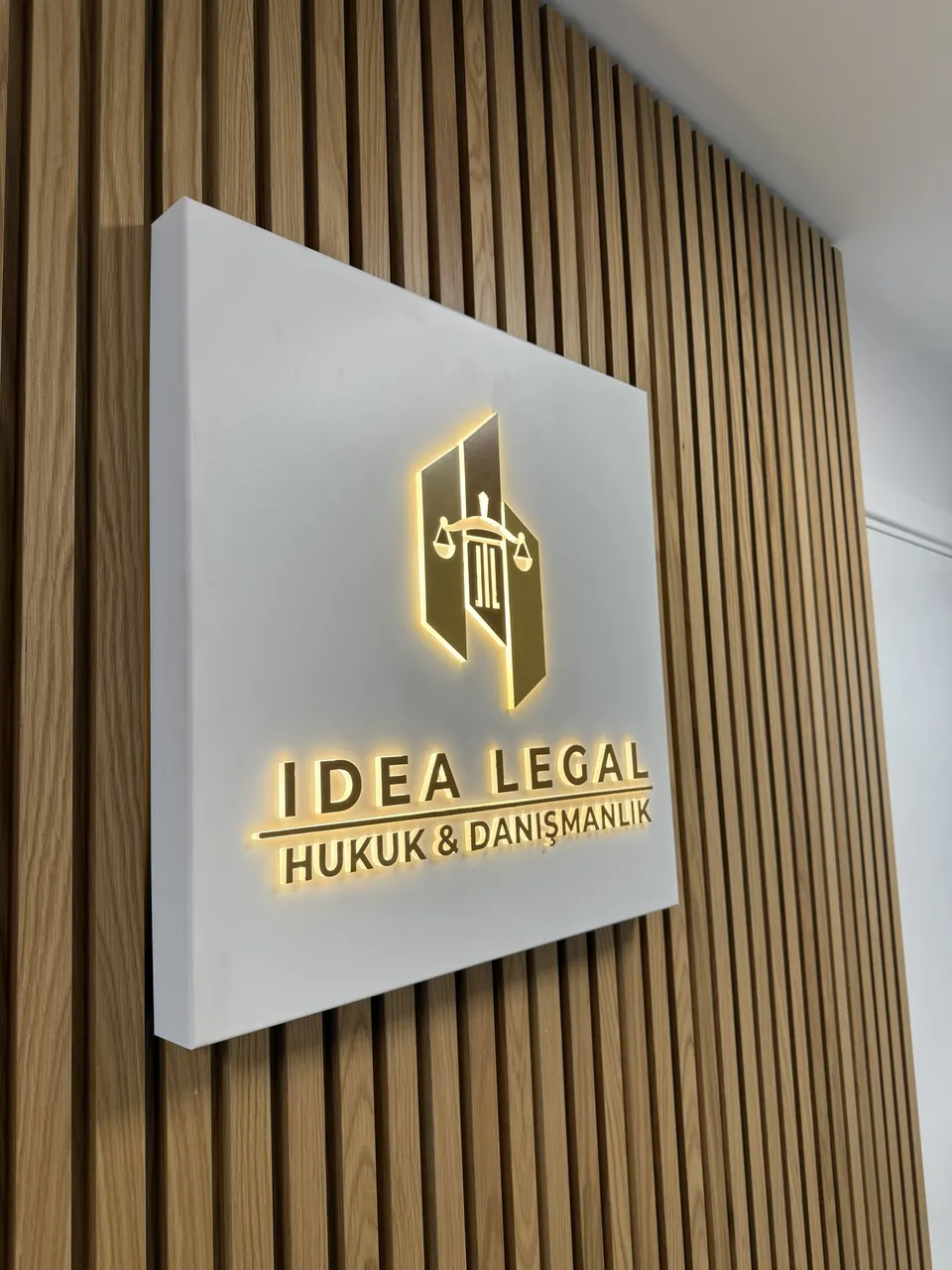 Idea Legal Hukuk ve Danışmanlık için çıtalı duvarda aydınlatmalı logo panosu.
