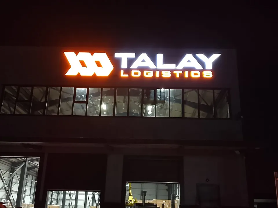 Talay Logistics ışıklı fabrika cephe tabelası, gece görünümü.