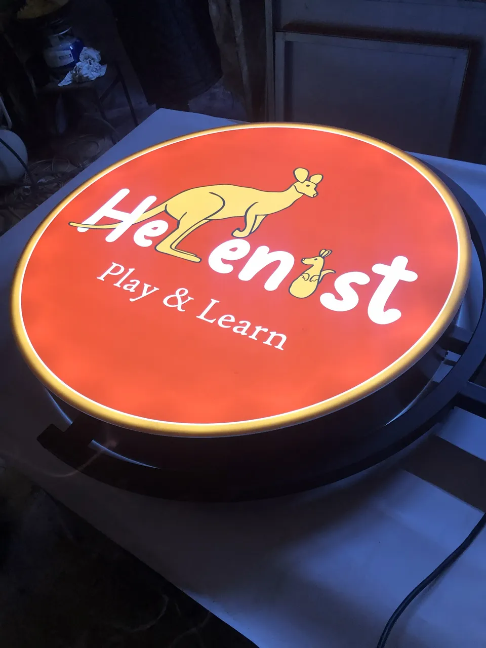 Helenist Play and Learn için kırmızı yuvarlak ışıklı fener tabela, yakın görünüm.