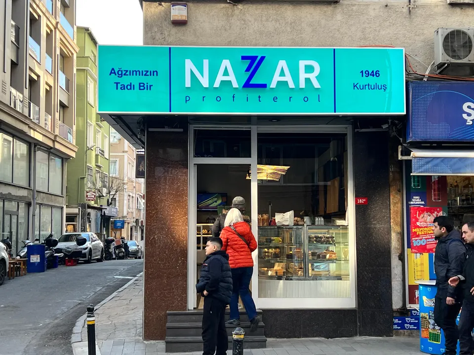 Nazar Politerol turkuaz ışıklı mağaza alınlık tabelası, karşıdan görünüm.
