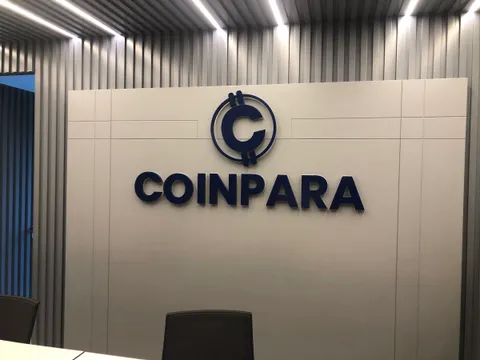 Coinpara için lacivert kabartma logo ve harfler, beyaz duvar panelinde, arkada gri çıtalı ofis duvarı, yakın açı.