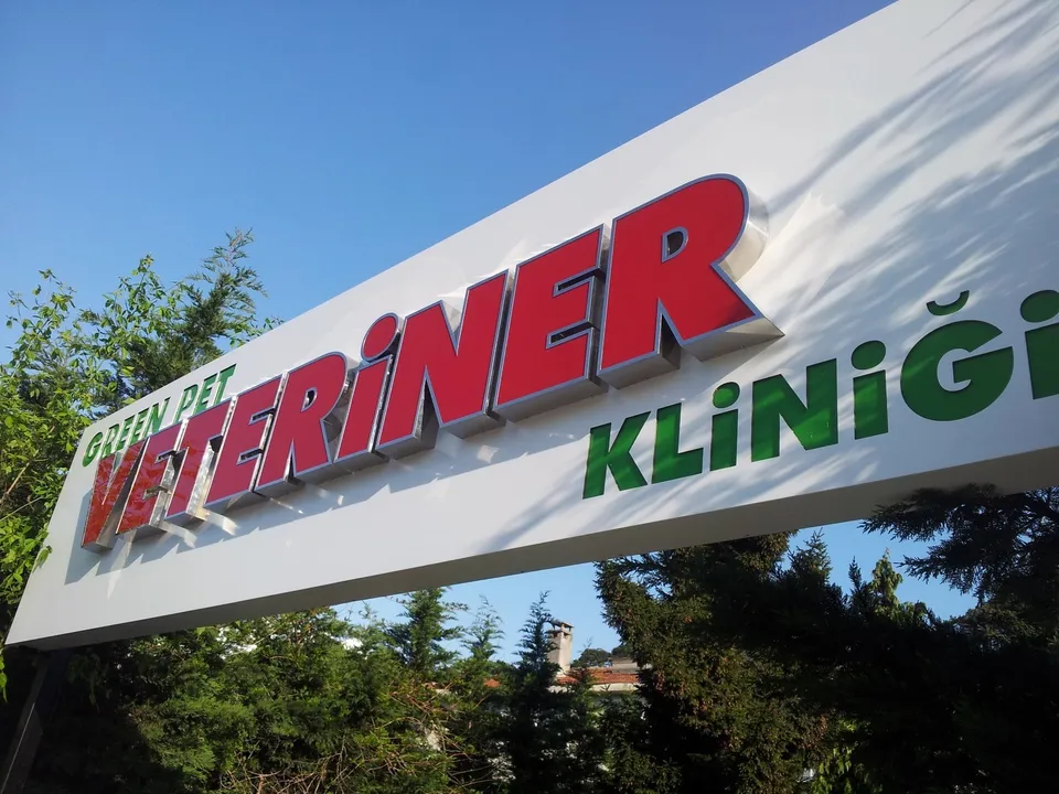 Green Pet Veteriner Kliniği kırmızı-yeşil paslanmaz cephe harfleri, yakın görünüm.