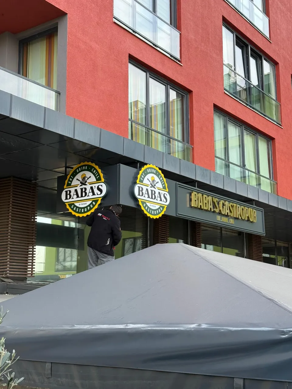 Baba’s Gastropub cephe tabelası ve yuvarlak fener logolar, çapraz görünüm.