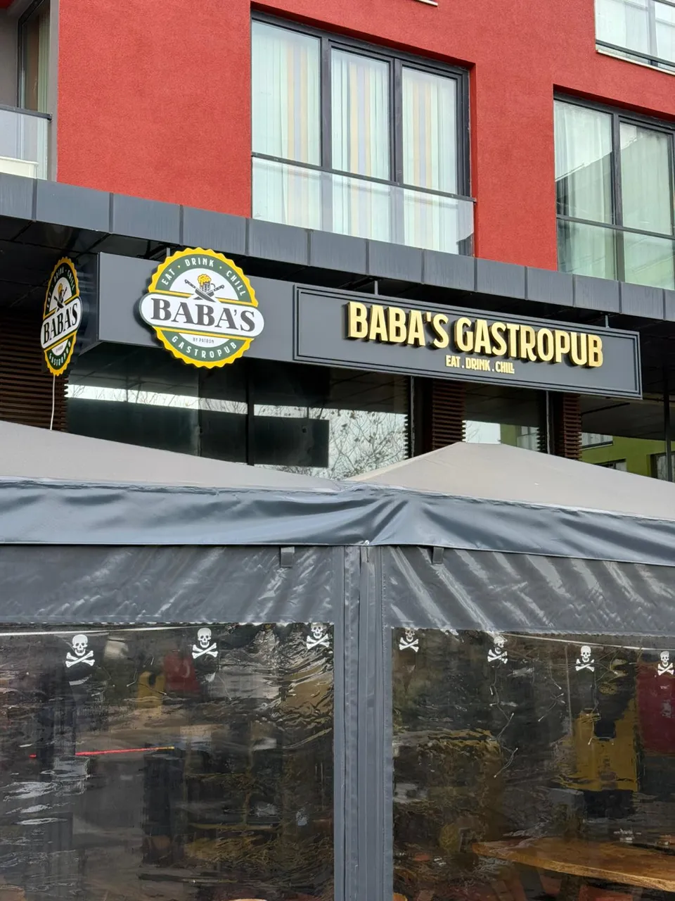 Baba’s Gastropub altın paslanmaz cephe harfleri, tente üzerinden görünüm.