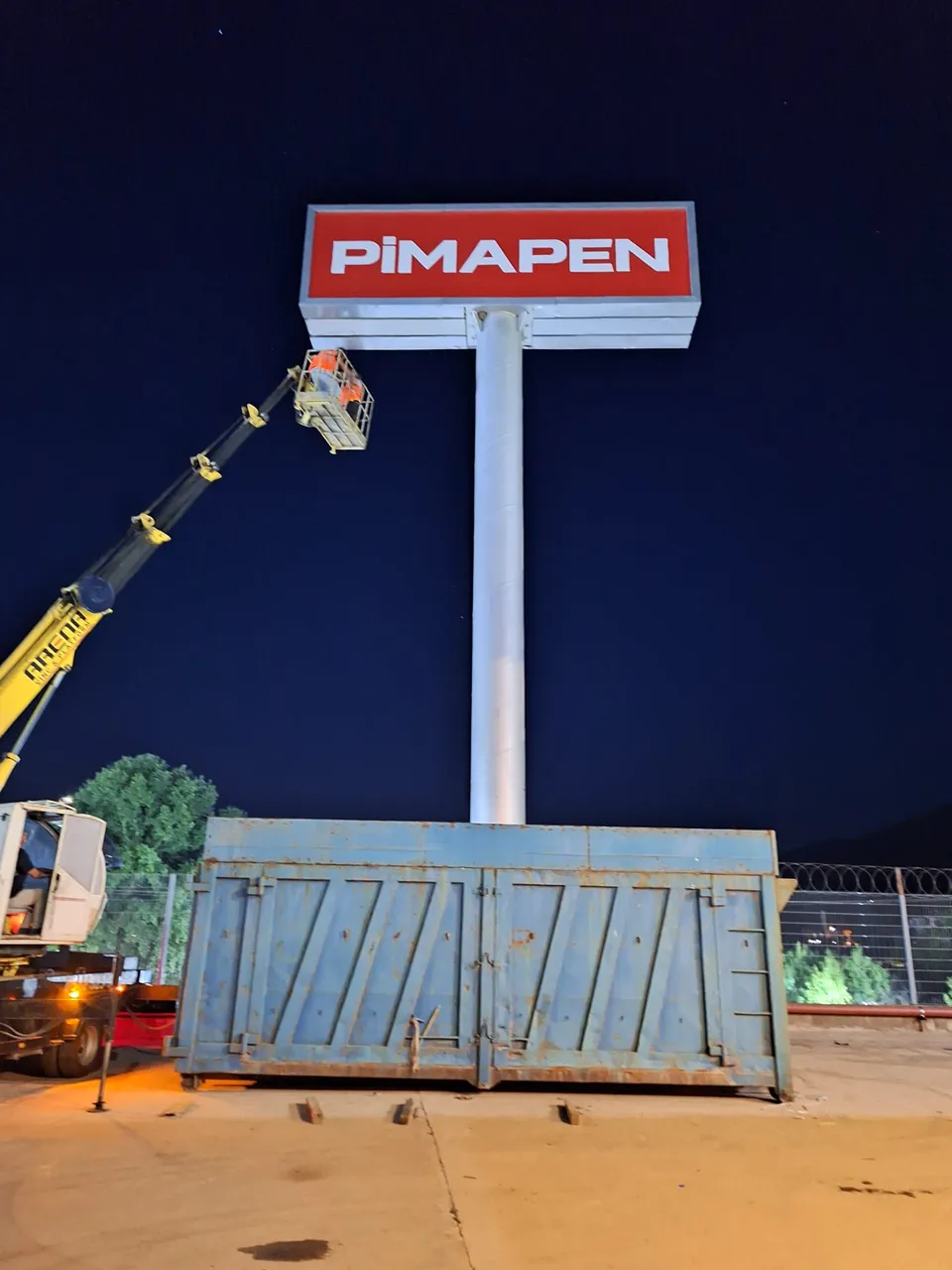 Pimapen kırmızı-beyaz yüksek totem tabelasının gece vinçle montajı.